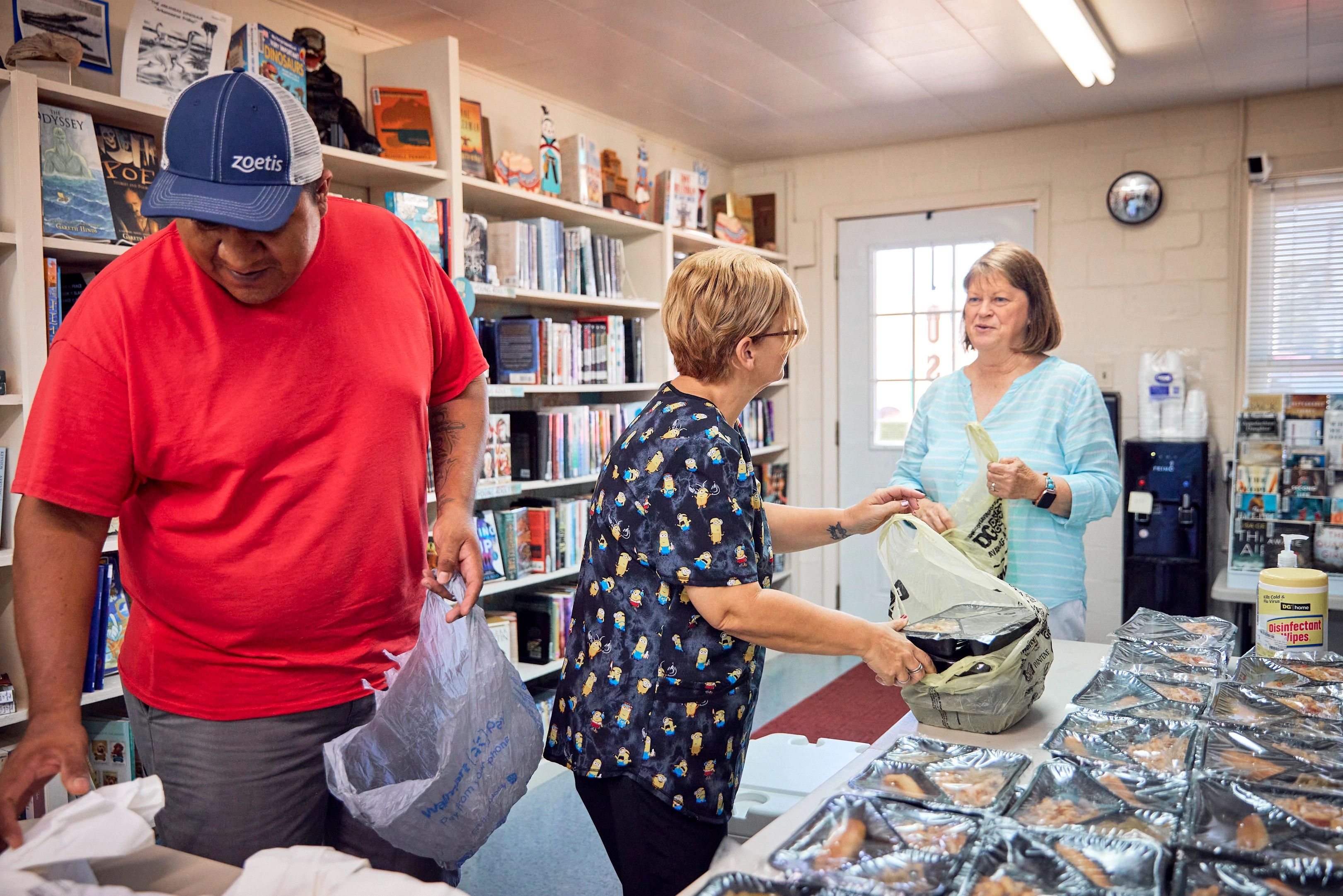 two parent caregivers pick up meals for their children from their local library