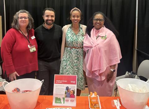 No Kid Hungry staff and Denny's representative stand behind a tabling table