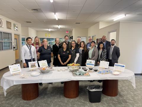 school staff stand behind a table with snacks and information for parents